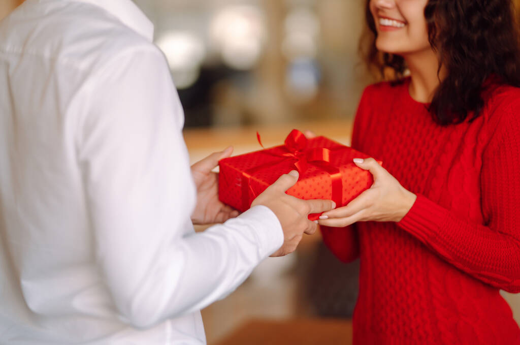 Výměna dárků. Mladý pár zamilovaný nabízí jeden druhému dárek k Valentýnu nebo narozeninám. Romantický den. Zimní dovolená. - Fotografie, Obrázek