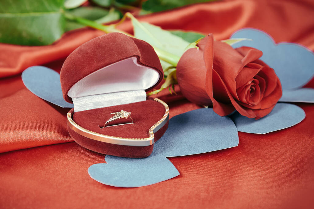 διαμαντένιο δαχτυλίδι και τριαντάφυλλο σε έντονο κόκκινο φόντο - Φωτογραφία, εικόνα