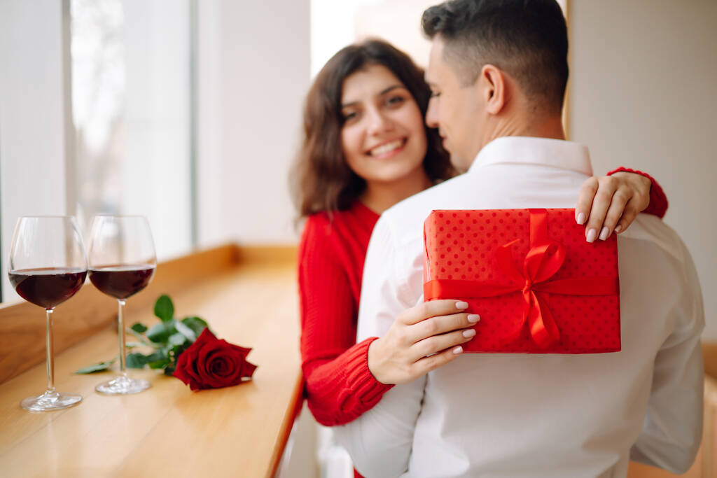 Giovane coppia con scatola regalo che abbraccia e celebra San Valentino. Rapporto, vacanza, sorpresa e amore concetto. - Foto, immagini