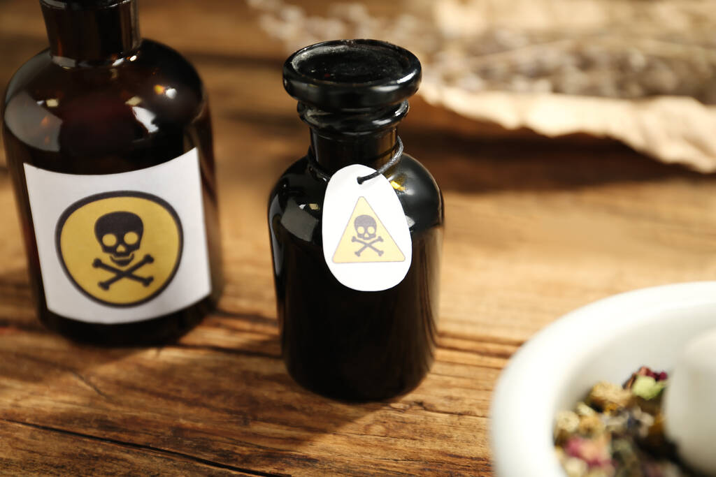 Bouteille de poison en verre ouverte avec panneau d'avertissement sur une table en bois, gros plan - Photo, image