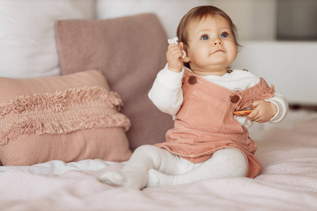 мила маленька дівчинка їсть печиво на ліжку
 - Фото, зображення