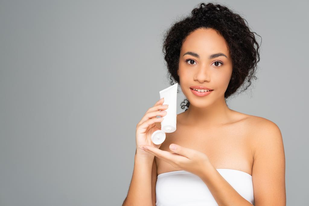 Afroamerikanerin mit perfektem Hauthalteschlauch mit Reinigungsschaum isoliert auf grau  - Foto, Bild