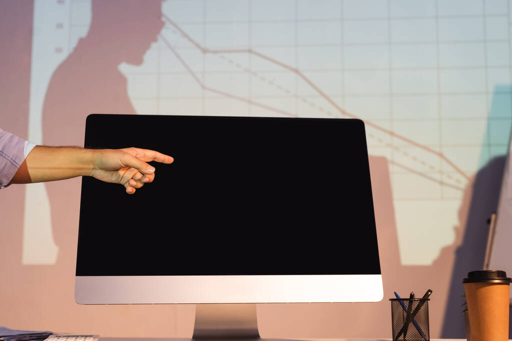 vista ritagliata di uomo d'affari che punta con il dito al monitor del computer con schermo vuoto - Foto, immagini