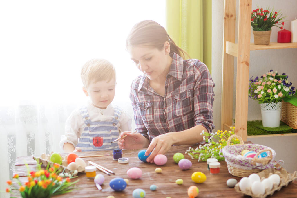 Madre e suo figlio dipingono uova di Pasqua. - Foto, immagini