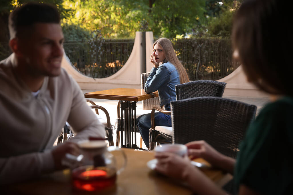 Eifersüchtige Ex-Freundin bespitzelt Paar in Outdoor-Café - Foto, Bild