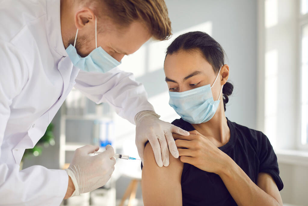 Patient masculin sous masque facial médical recevant le vaccin contre la grippe saisonnière ou le vaccin Covid-19 moderne - Photo, image