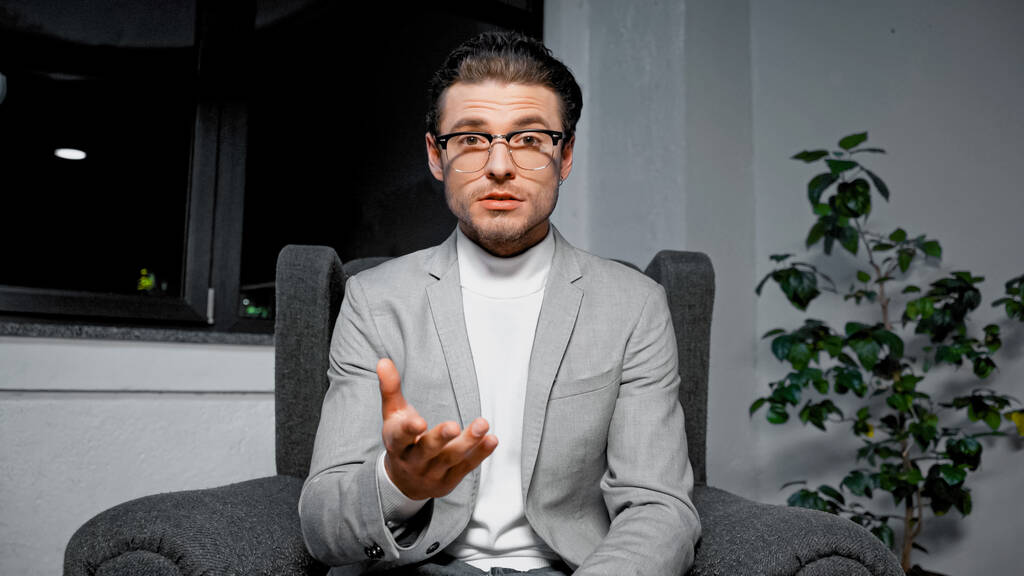 Young businessman pointing with hand at camera during video call  - Photo, Image