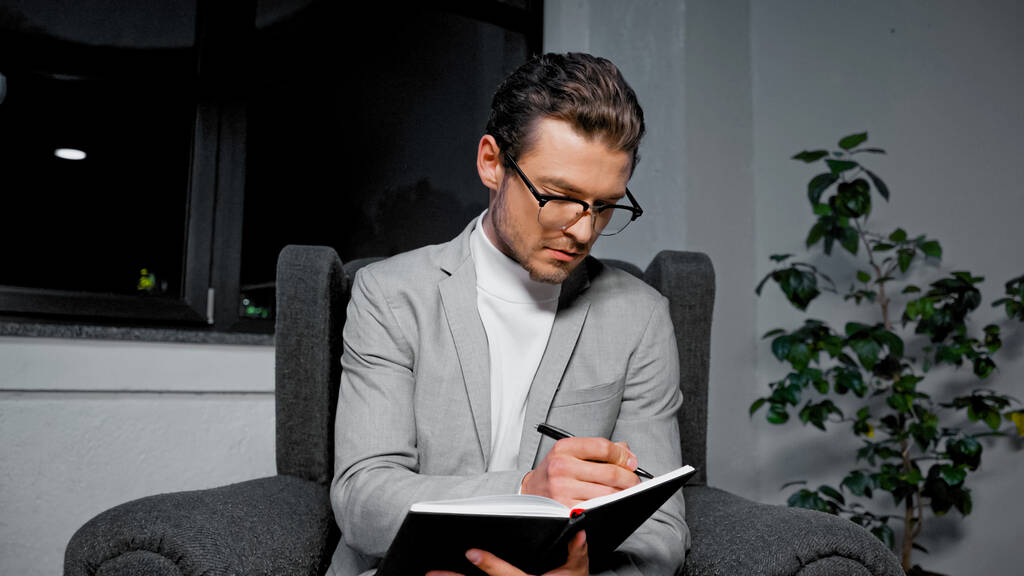 Mladý podnikatel psaní na notebook na křesle v kanceláři  - Fotografie, Obrázek