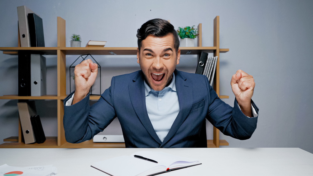 Возбужденный бизнесмен показывает да жест во время видео-чата в офисе  - Фото, изображение