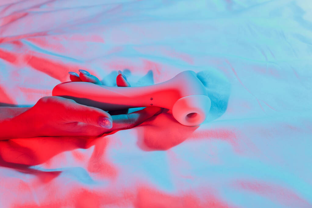 Contactloze Clitoral Stimulator Vrouw in slaapkamer met vibrator in de hand. - Foto, afbeelding