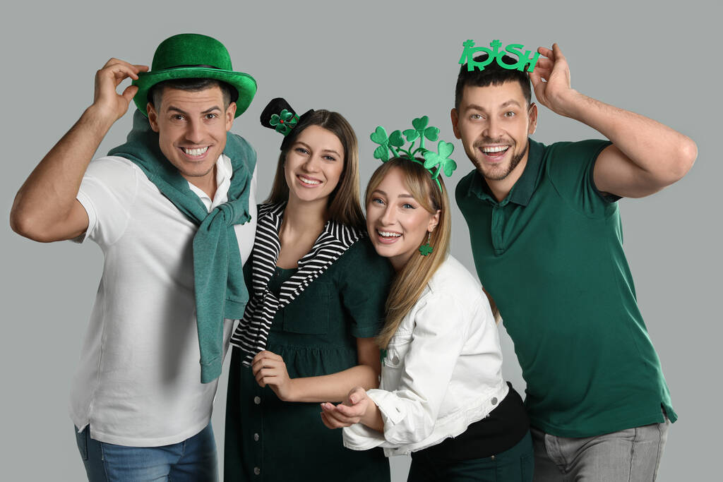Happy people in St Patrick's Day outfits on light grey background - Photo, Image