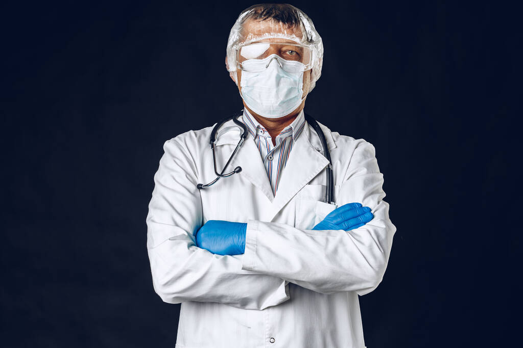 Male doctor wearing protective Mask and Goggles. Dark background. - Photo, Image