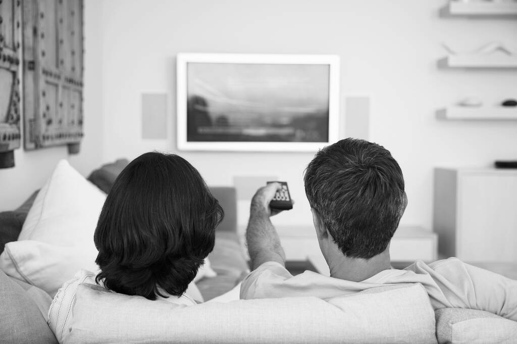 Black and white photo of couple watching television on lockdown - Photo, Image
