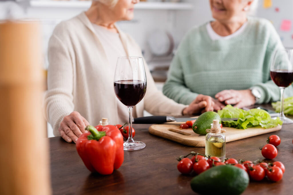 vista recortada de amigos mayores cerca de verduras frescas en la mesa  - Foto, imagen