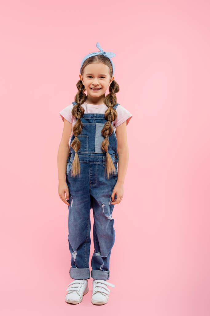 comprimento total da criança feliz sorrindo e de pé em rosa - Foto, Imagem