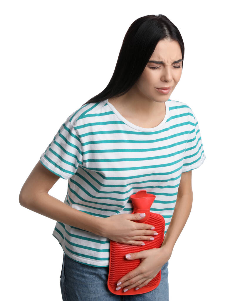 Mujer que usa botella de agua caliente para aliviar el dolor menstrual sobre fondo blanco - Foto, imagen