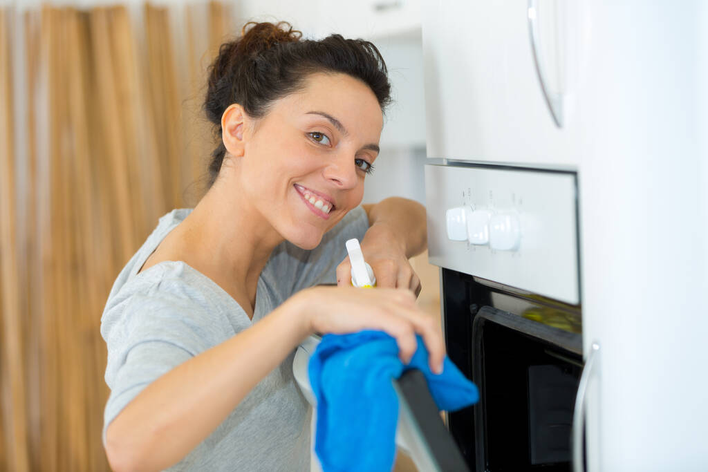 donna forno di pulizia con straccio - Foto, immagini