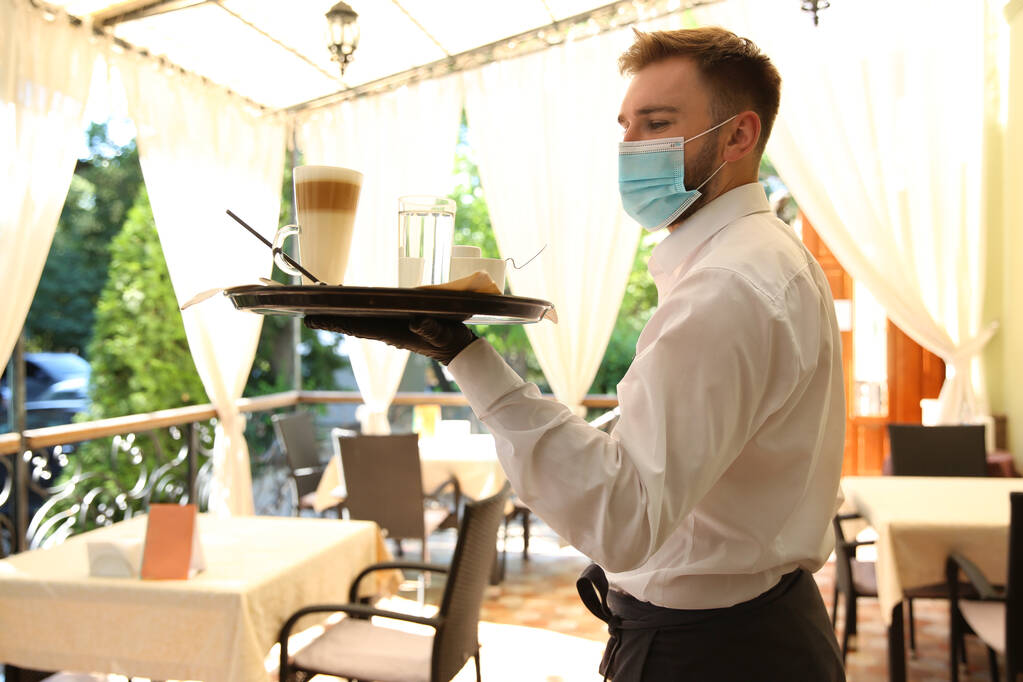 Serveur servant des boissons au restaurant. Restauration pendant la quarantaine du coronavirus - Photo, image