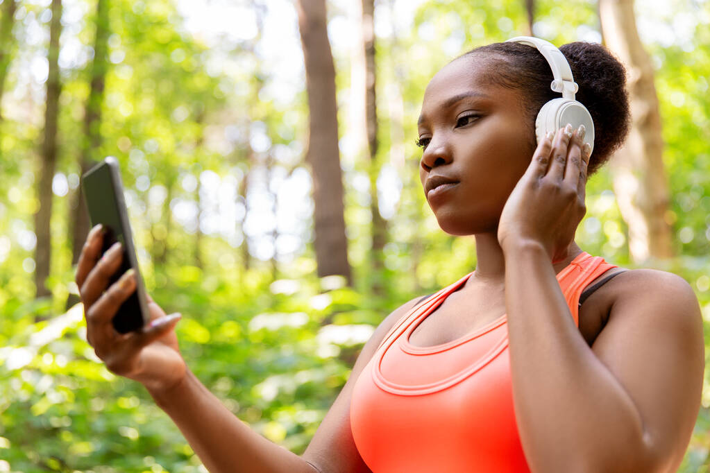 Afrikanerin mit Kopfhörer und Telefon - Foto, Bild