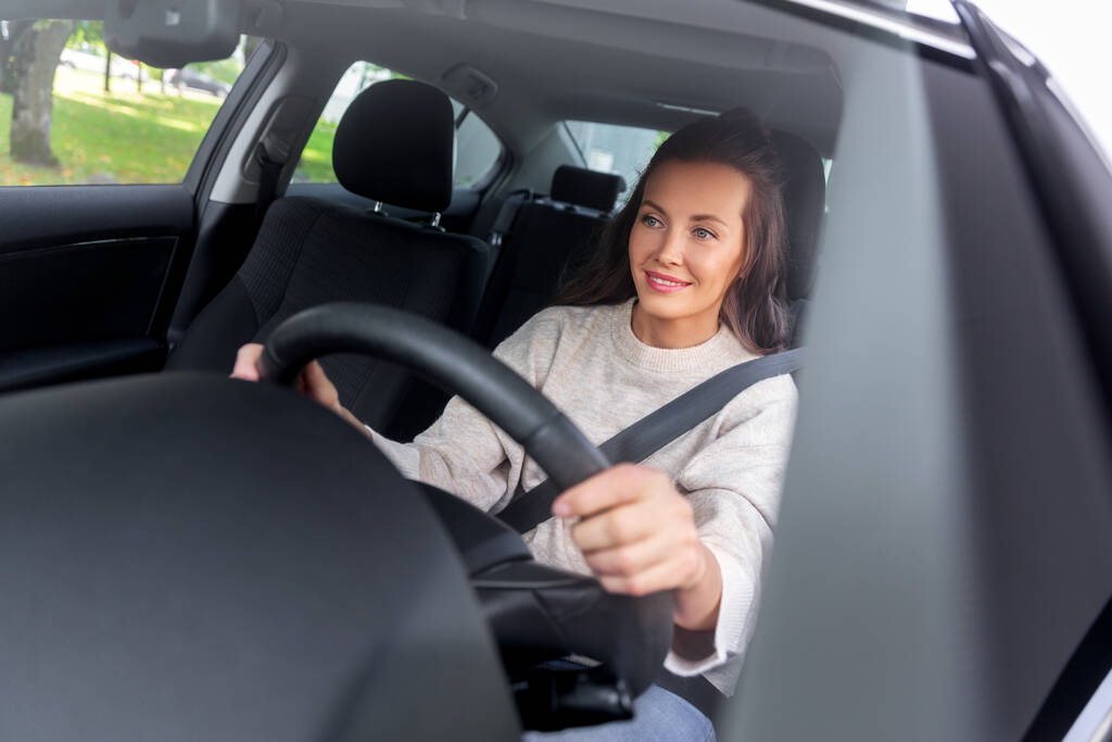 mosolygós nő vagy női vezető vezetés autó a városban - Fotó, kép