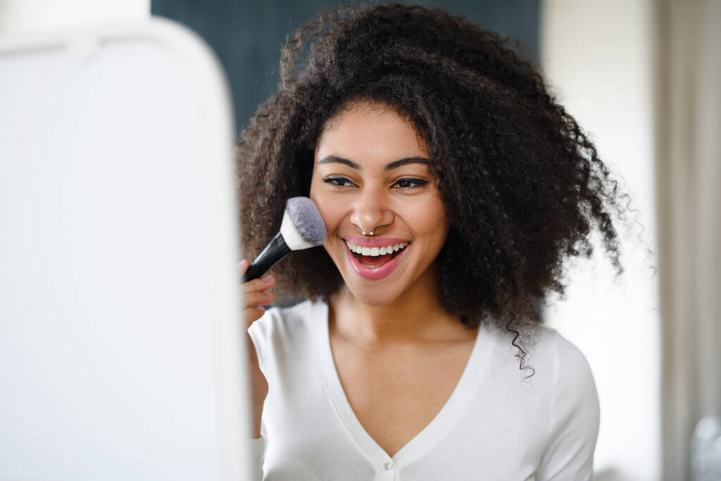 Gros plan portrait de jeune femme avec brosse à l'intérieur à la maison, appliquer le maquillage. - Photo, image