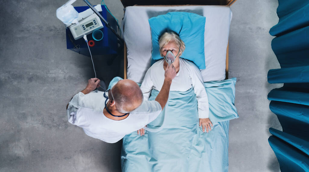Hastane yatağında oksijen maskesi takan doktor ve kovid 19 hastası, koronavirüs konsepti.. - Fotoğraf, Görsel