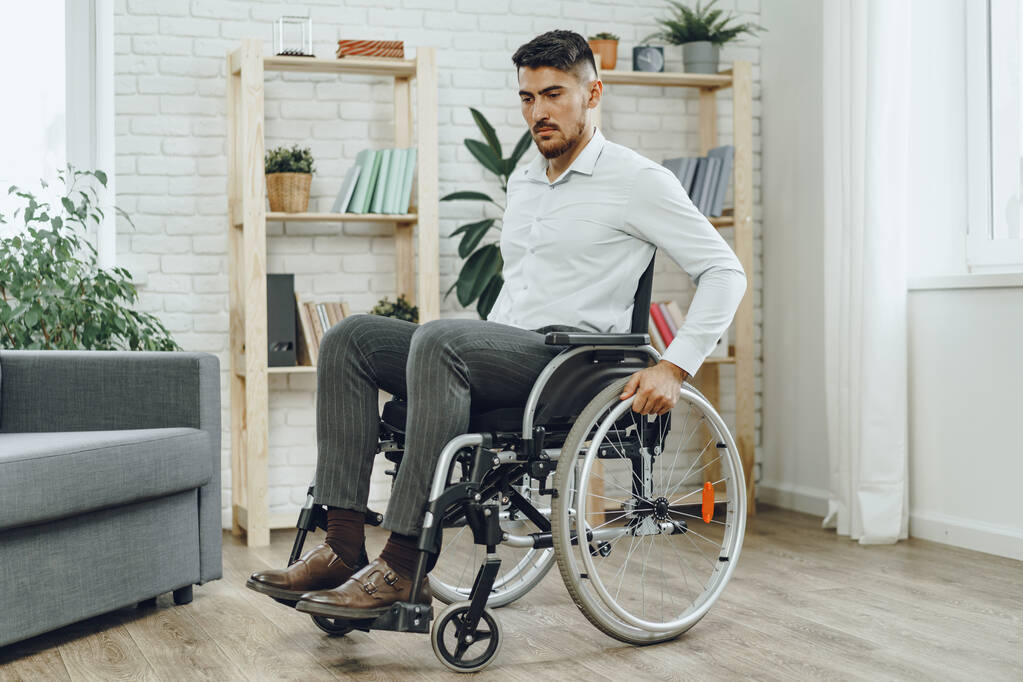 Vammaisen juhlapukuisen miehen muotokuva istuu pyörätuolissa - Valokuva, kuva