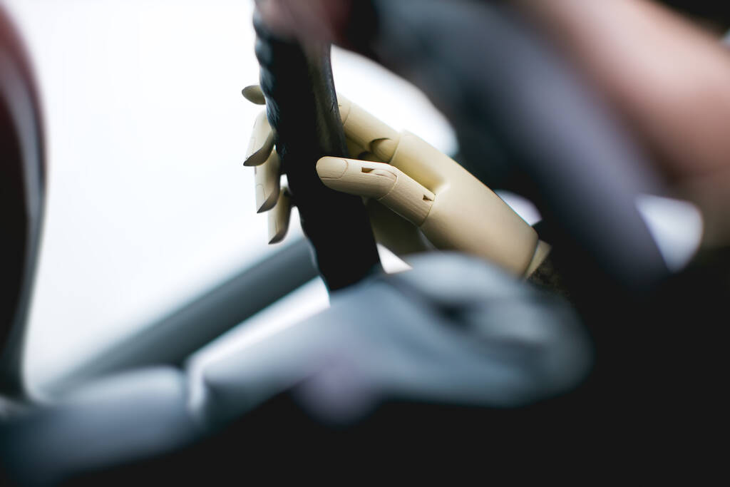 управляющий автомобиль с искусственной рукой - Фото, изображение