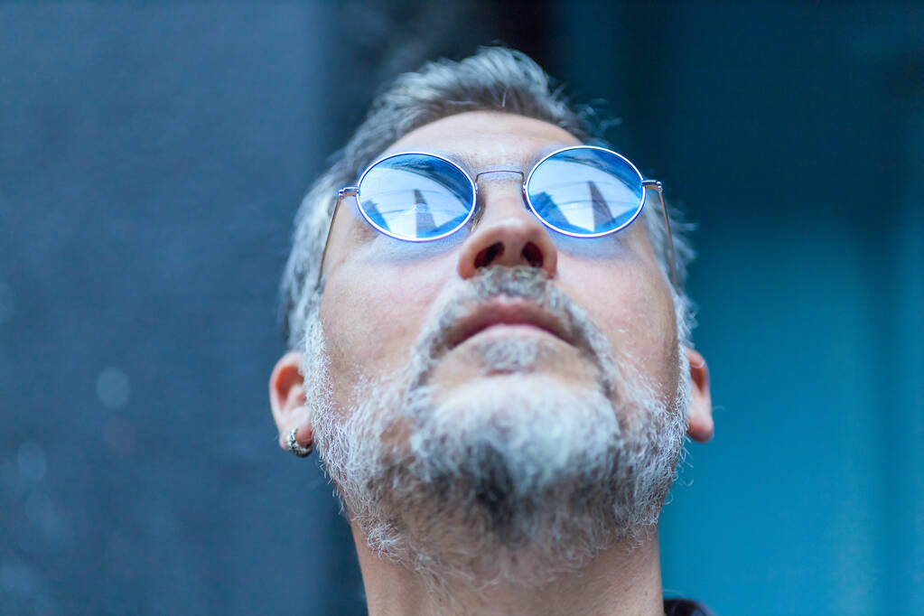portrait of a man with blue sunglasses looking up - Photo, Image
