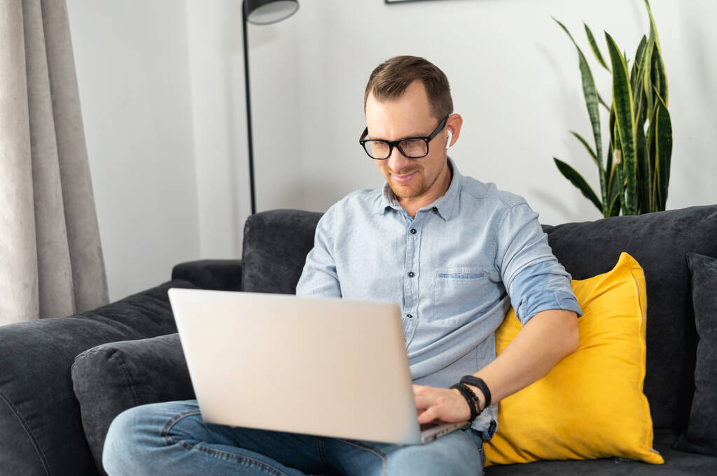 Um cara freelancer está usando laptop em casa - Foto, Imagem