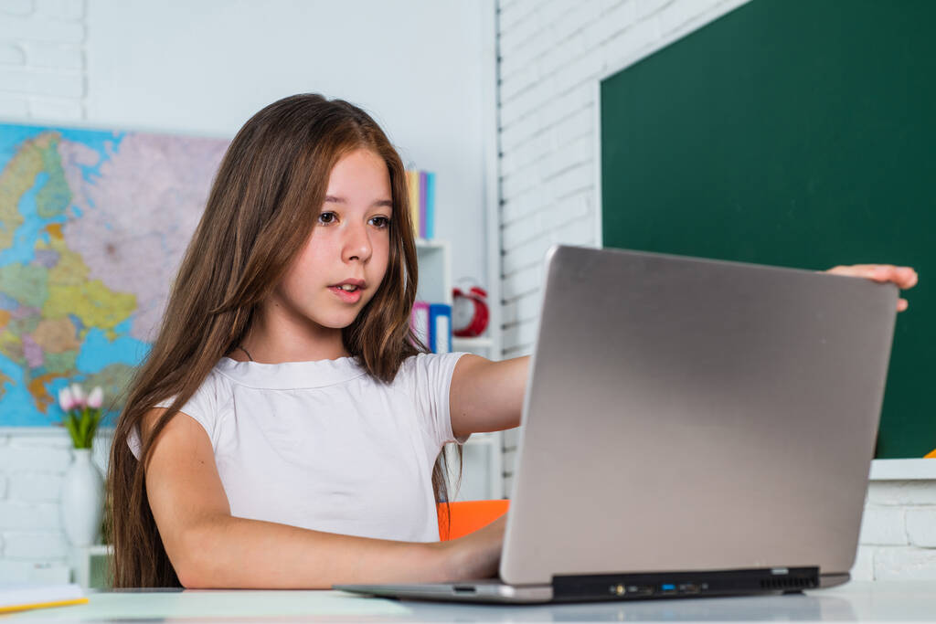 wesoły dzieciak dziewczyna z komputera na lekcjach szkolnych, e-learning - Zdjęcie, obraz