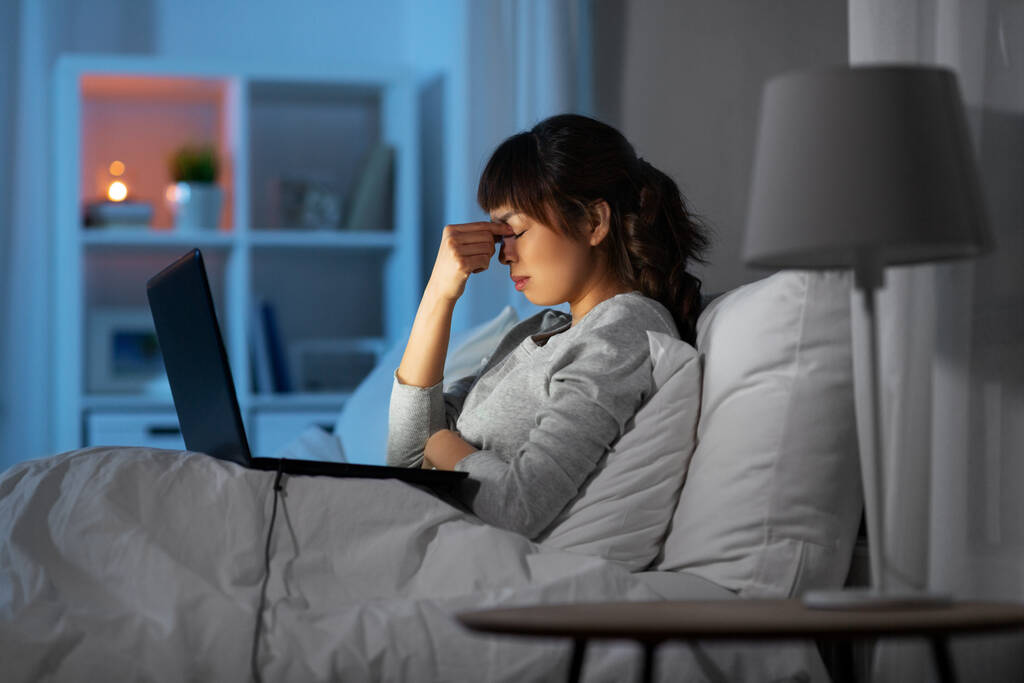stresszes nő laptop dolgozik az ágyban éjszaka - Fotó, kép