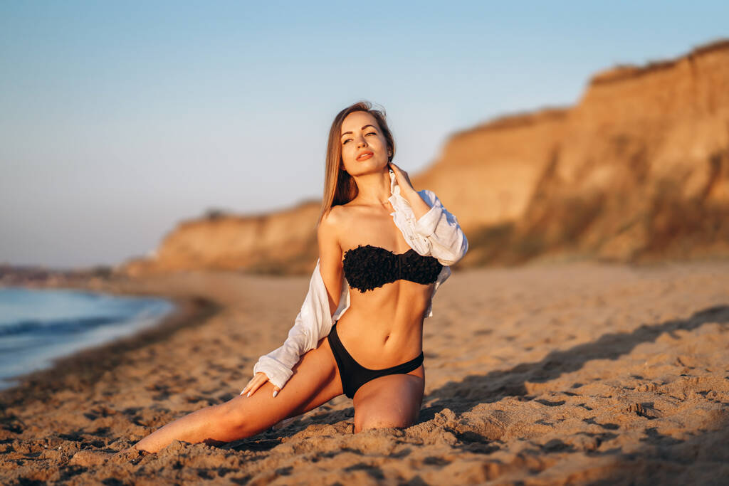 Hezká brunetka žena relaxující na pláži u moře - Fotografie, Obrázek