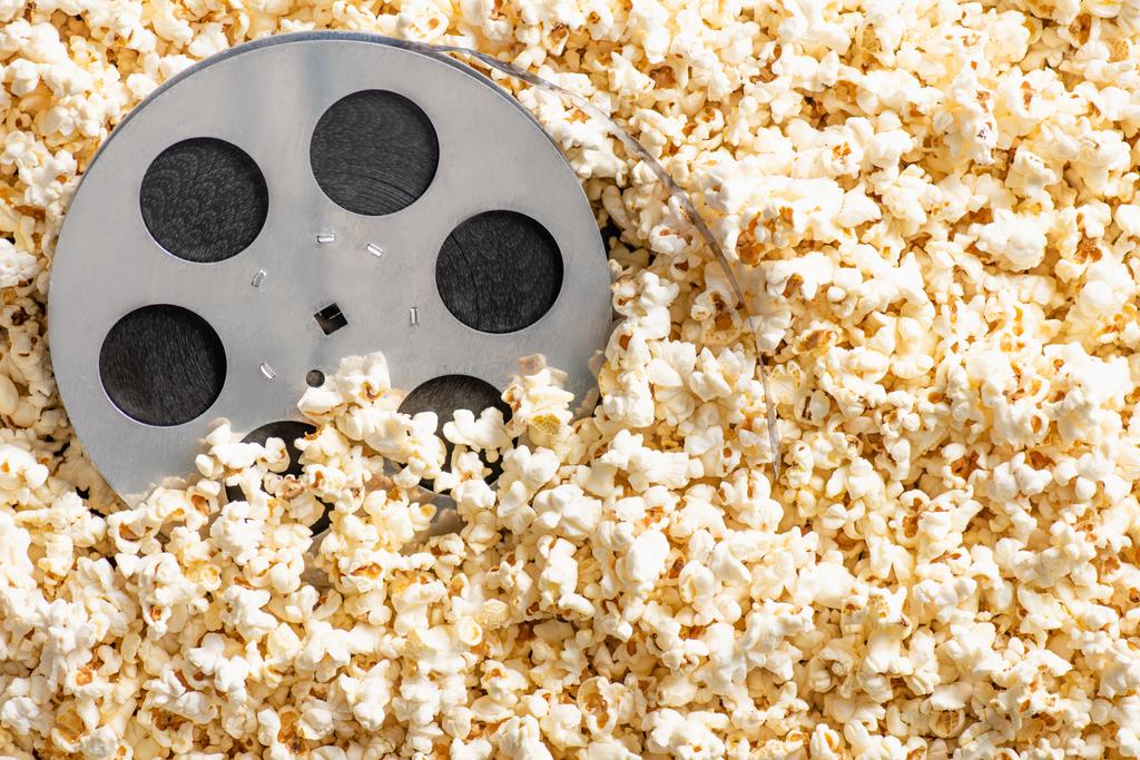 top view film tekercs ízletes popcorn, mozi koncepció - Fotó, kép