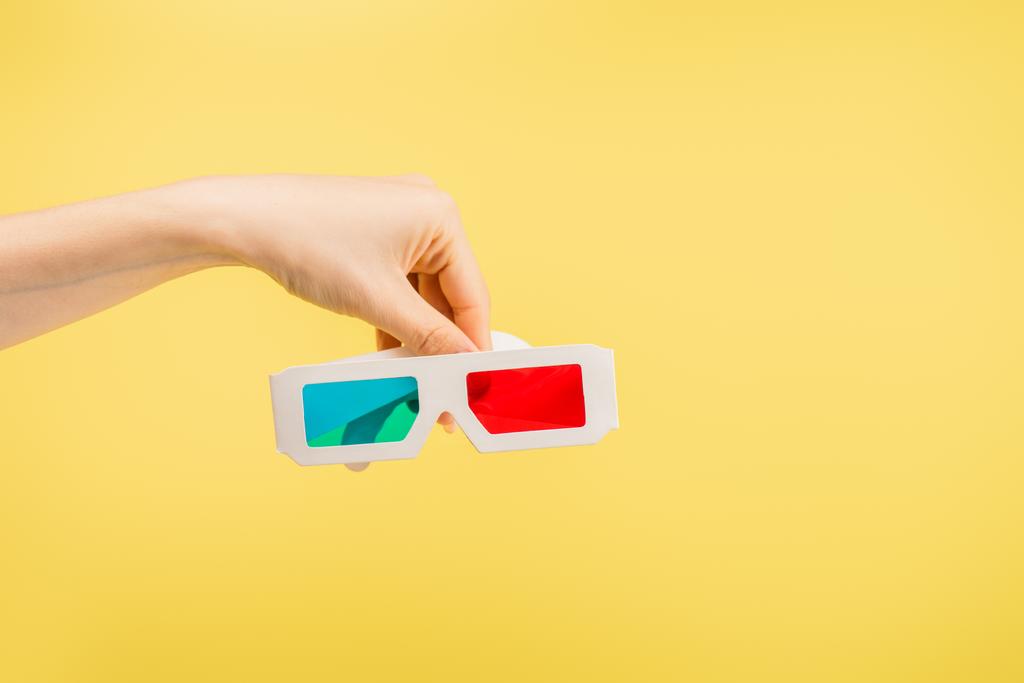 vista parcial de la mano femenina con gafas 3d aisladas en amarillo, concepto de cine - Foto, Imagen