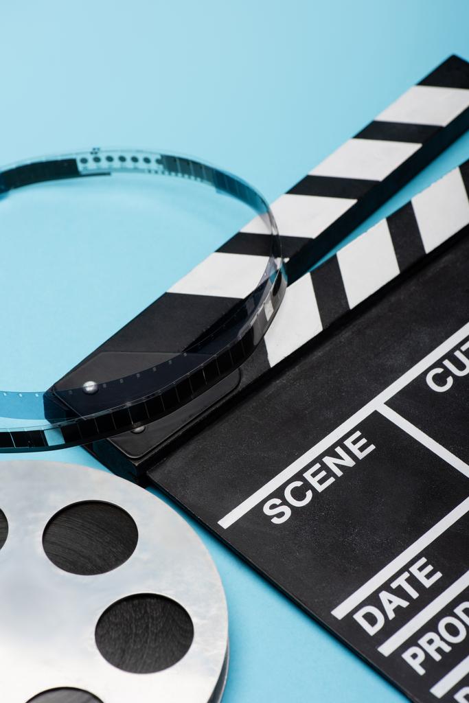 primer plano vista de carrete de película y clapperboard en azul, concepto de cine - Foto, Imagen