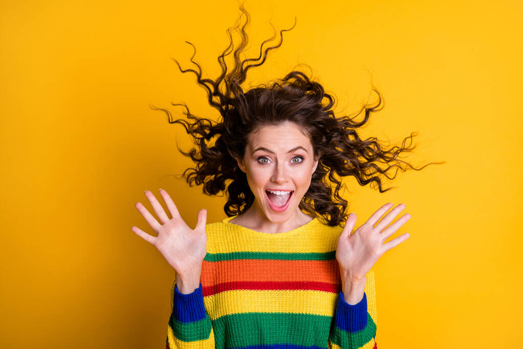Fotografie šokované překvapené ženy oblečené ležérní barevné mikiny vítr foukání vlasy otevřená ústa izolované žluté barvy pozadí - Fotografie, Obrázek