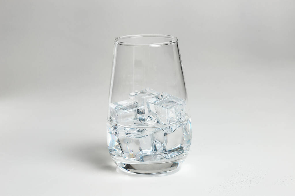 do skleněného kelímku se nalije čistá voda. led ve sklenici. - Fotografie, Obrázek