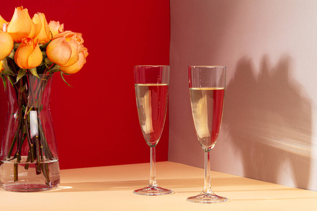 Nahaufnahme von Champagnergläsern mit Rosen in einer Vase - Foto, Bild