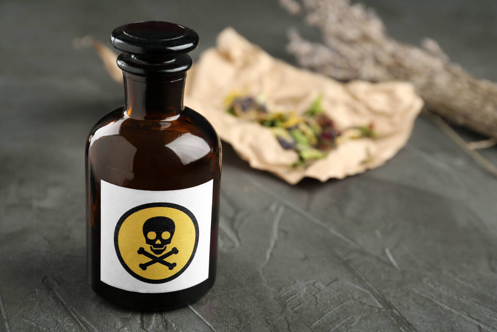 Bouteille de poison en verre avec panneau d'avertissement sur table en pierre grise. Espace pour le texte - Photo, image