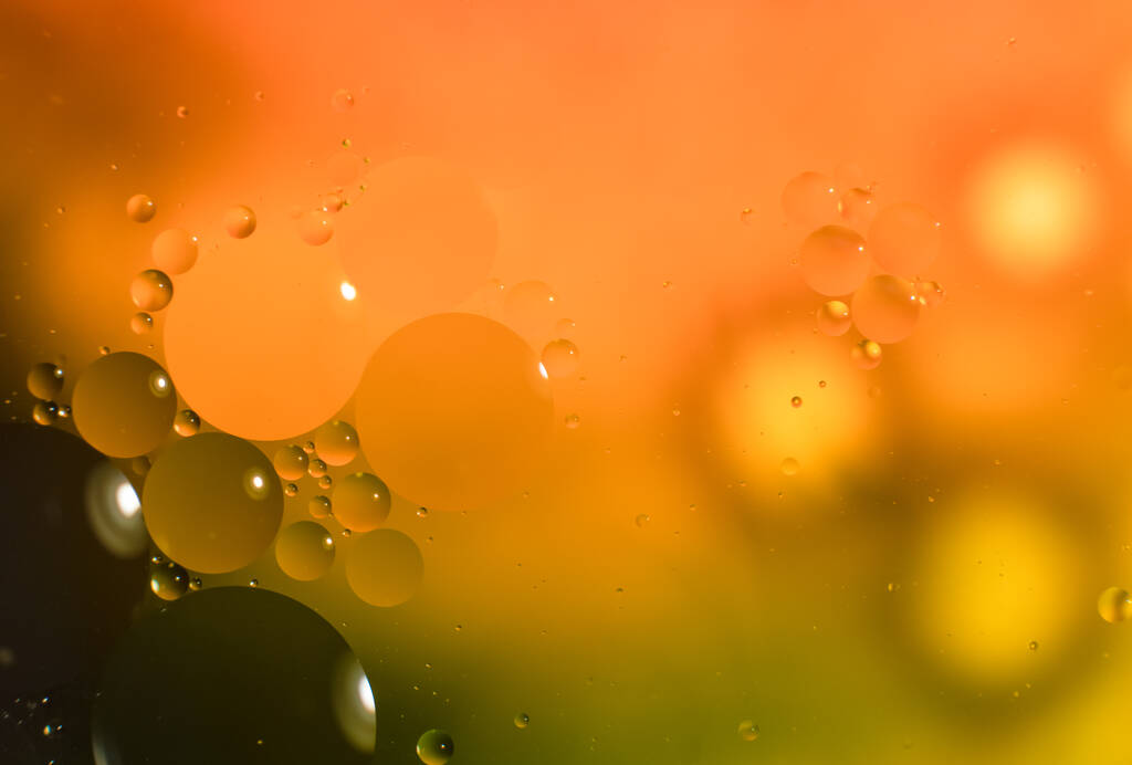 Fundo abstrato com gotas de óleo coloridas na água. Imagem de padrão psicodélico. Esferas em amarelo desfocado e fundo de cor verde. Gotas de óleo e shaddows em uma água. - Foto, Imagem