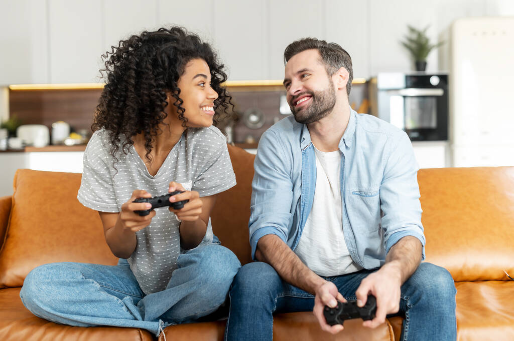 Couple multiracial jouant sur la console - Photo, image