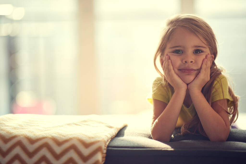 Una niña posando para una foto en un ambiente tranquilo del hogar. Niño, casa, jugando - Foto, imagen