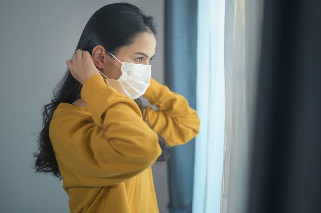 A young beautiful woman wearing a protective facial mask getting ready to go outside, Healthcare and covid-19 concep - Photo, Image