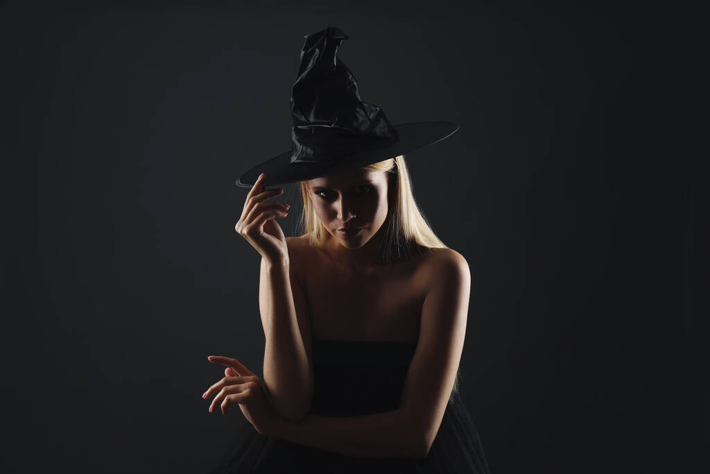 Bruxa de chapéu preto no fundo escuro. Personagem de fantasia assustadora - Foto, Imagem