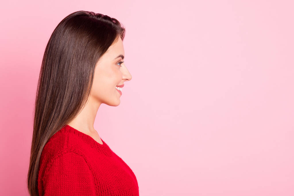 Profiel foto van jonge mooie dame kijken lege ruimte stralen witte glimlach dragen rode trui geïsoleerde roze kleur achtergrond - Foto, afbeelding