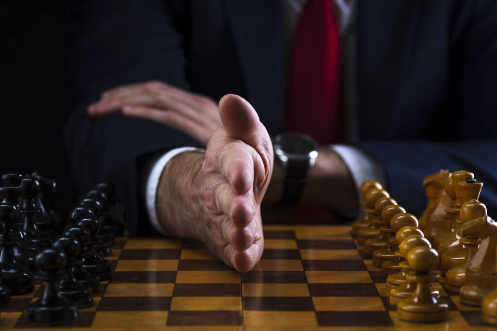 das Konzept der Strategie und Geschäftsplanung, ein Geschäftsmann an einem Schachbrett mit Figuren an ihren Plätzen, Strategie und Taktik, Kampfbereitschaft. - Foto, Bild