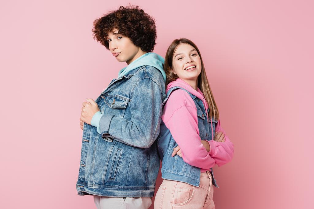 Les adolescents en vêtements décontractés regardant la caméra sur fond rose - Photo, image