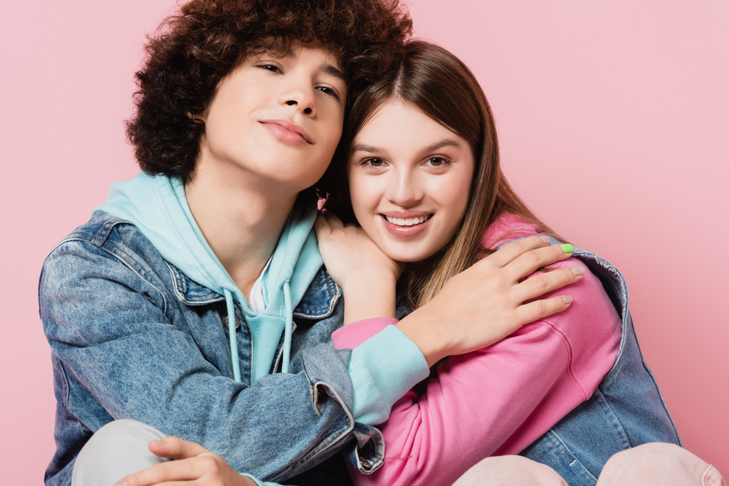 Усміхнені підлітки обіймаються ізольовано на рожевому
  - Фото, зображення