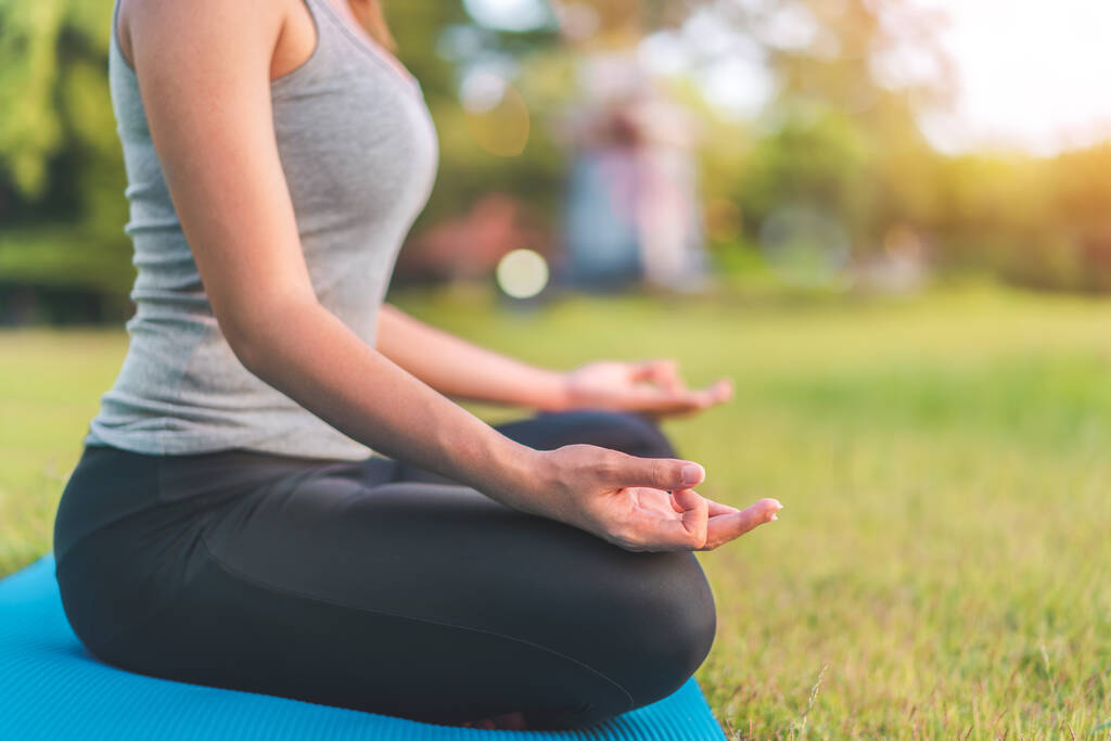 Asyalı kadın meditasyon yapıyor ve lotusta oturuyor. Parkta poz veriyor, Sağlıklı ve Yoga Kavramı, Zihin-Vücut Geliştirme Konsepti, Seçici Odaklanma, Boşluğu Kopyalama. - Fotoğraf, Görsel
